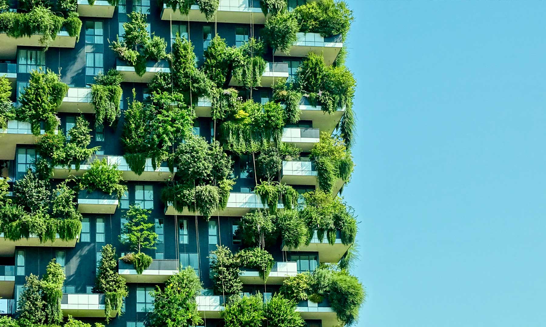A residential building with green foliage growing on all floors