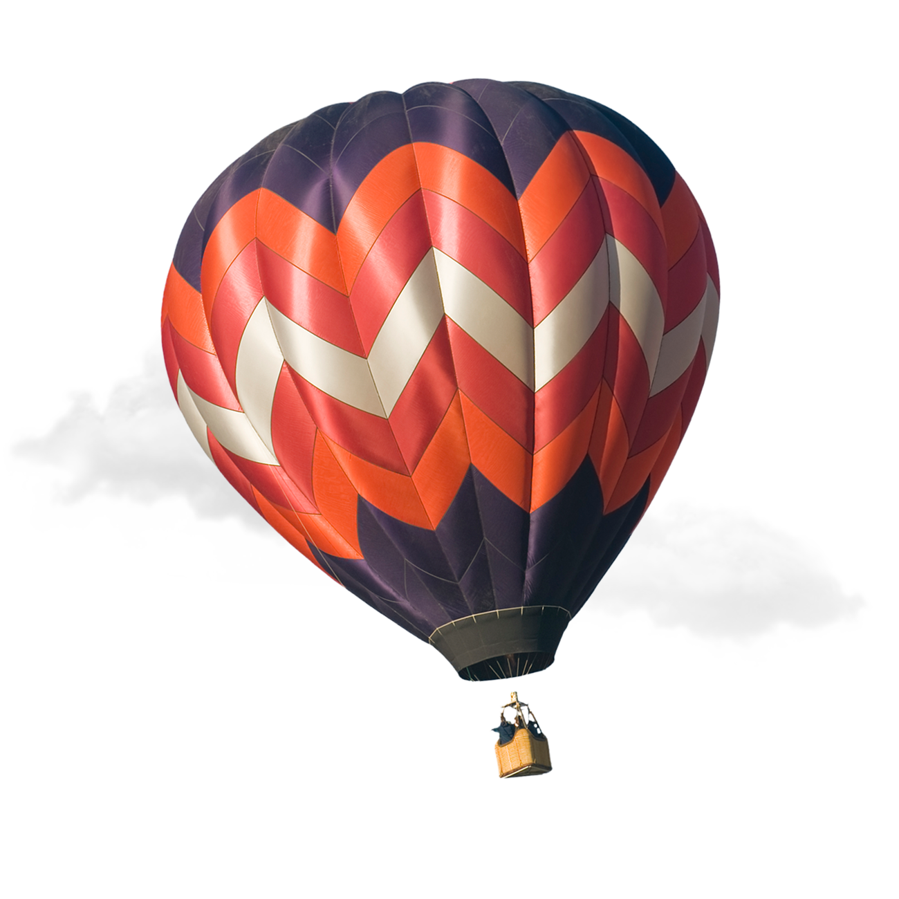 A red white and navy blue patterned hot air balloon floats in the clouds