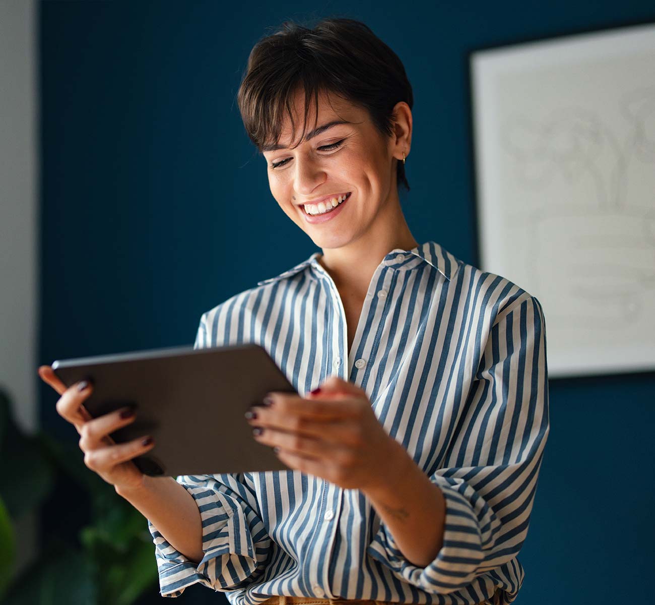 Smiling young brunette holding a tablet