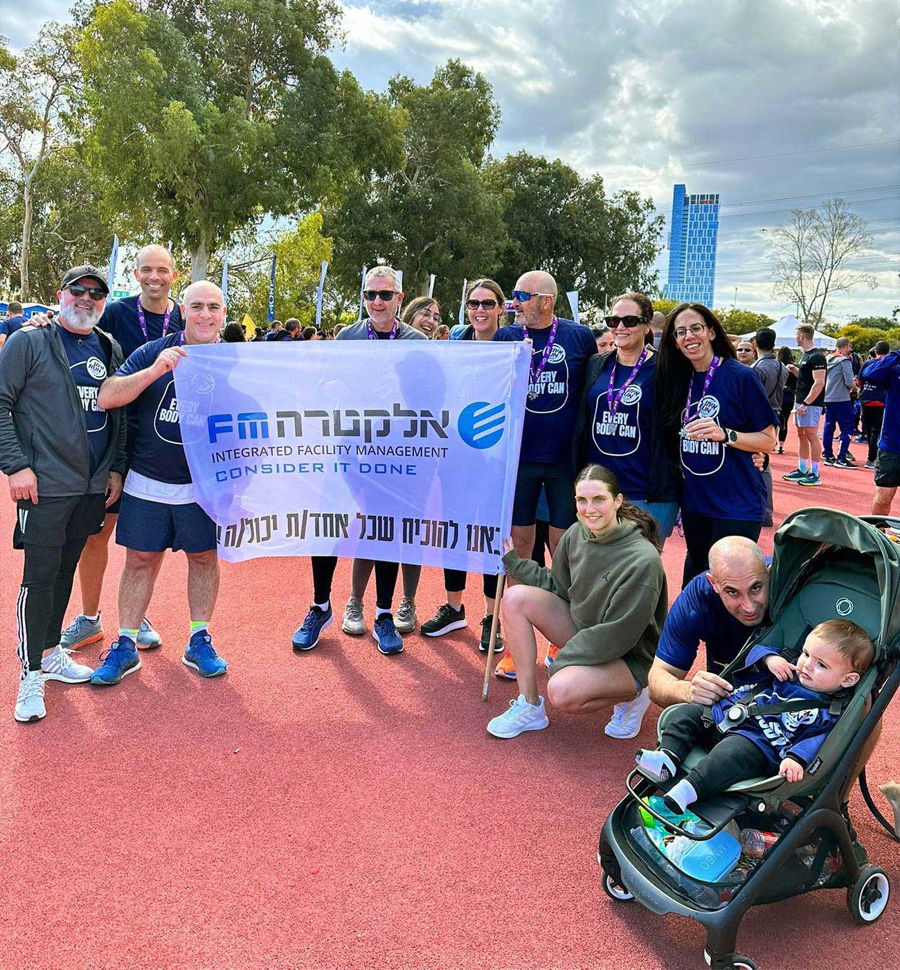 Members of the Electra FM team hold a sign at a running event