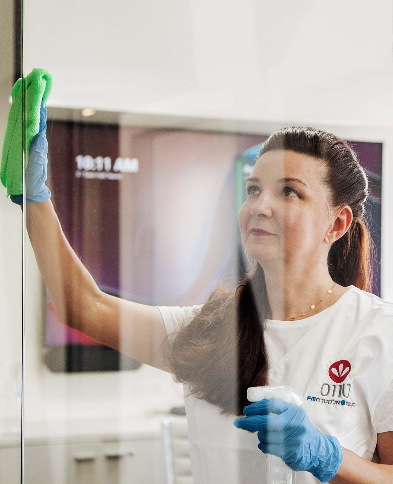 Brunette woman in Tavas uniform cleaning glass