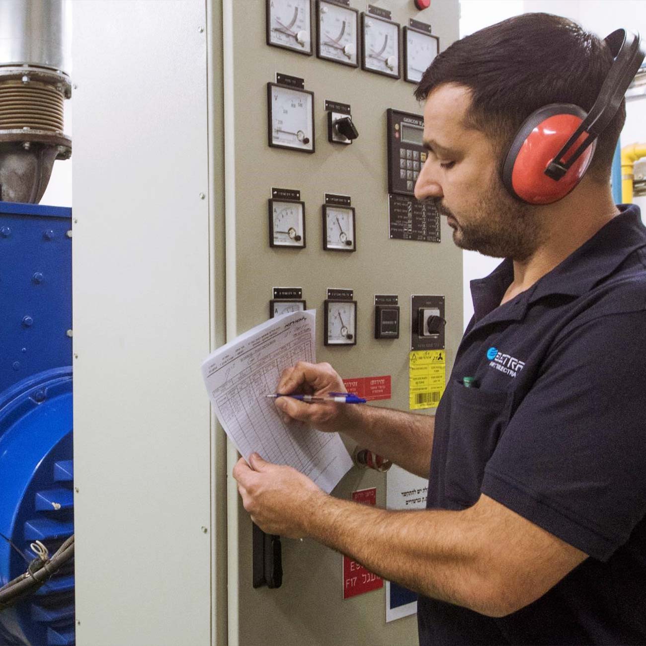 An Electra FM electrician works on an electrical panel