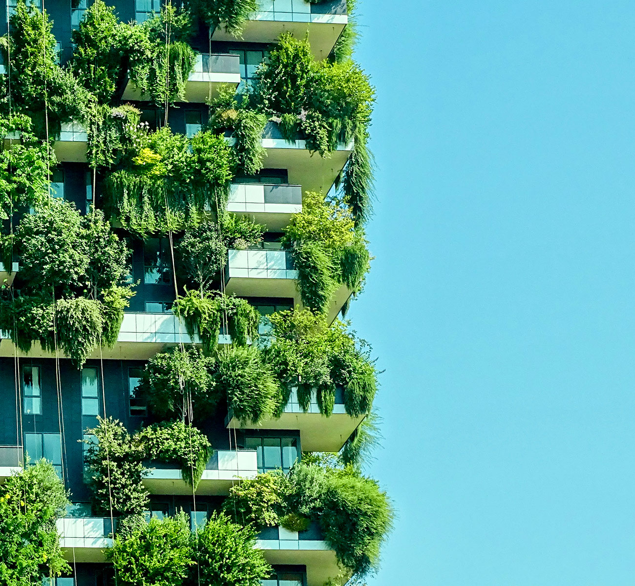 A high-rise residential building with lush foliage