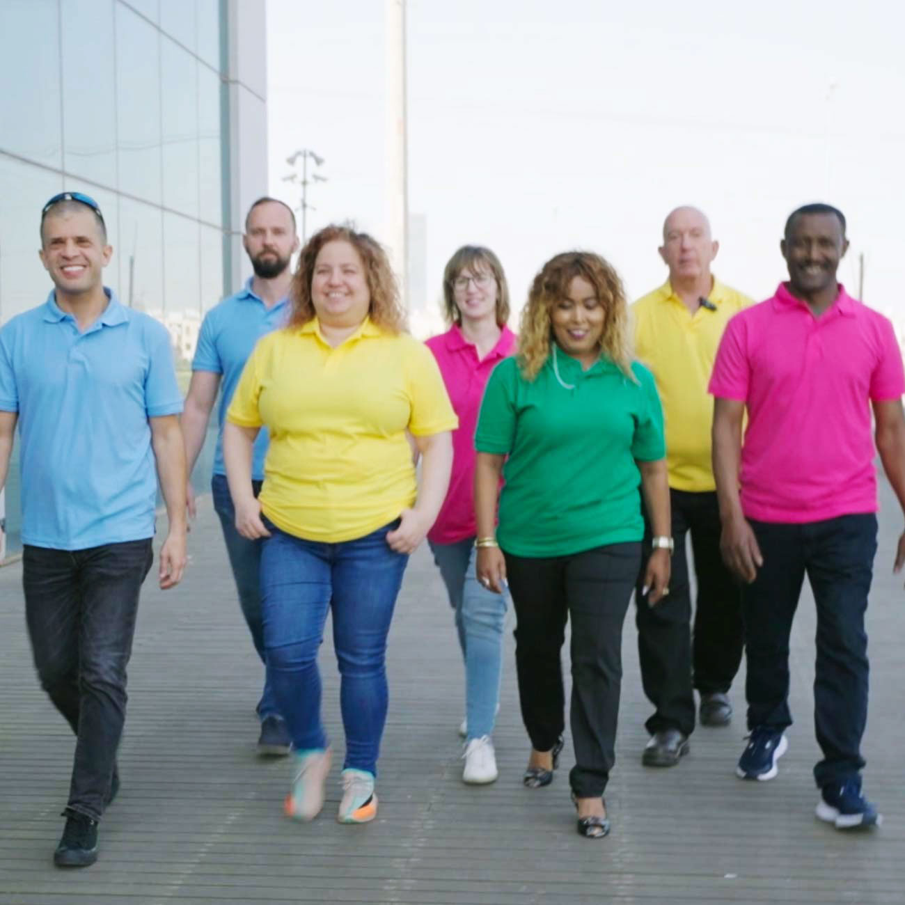 עובדי אלקטרה FM צועדים יחד בחולצות פולו ססגוניות