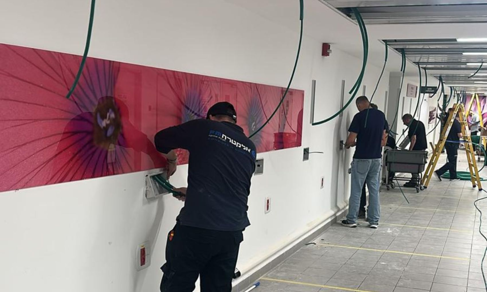 במהלך מלחמת "עם כלביא", צוות חשמלאים מחטיבת האחזקה של אלקטרה FM הוזעק במיידיות להקמת שתי מחלקות חירום במרתף בית חולים אסותא אשדוד. המשימה: להפוך מרתף ריק למחלקה רפואית מתפקדת תוך פחות מ-24 שעות, כהכנה להעברת חולים מהקומות העליונות בעקבות האיום האיראני. הצוותים עבדו ברציפות והקימו מערכת שלמה של תשתיות חיוניות - חשמל מורכב, מיזוג מותאם, גזים רפואיים, תקשורת ומערכות בטיחות. המחלקה נפתחה בדיוק כמתוכנן ביום שישי בבוקר, ופעילות הצלת החיים החלה מיד.